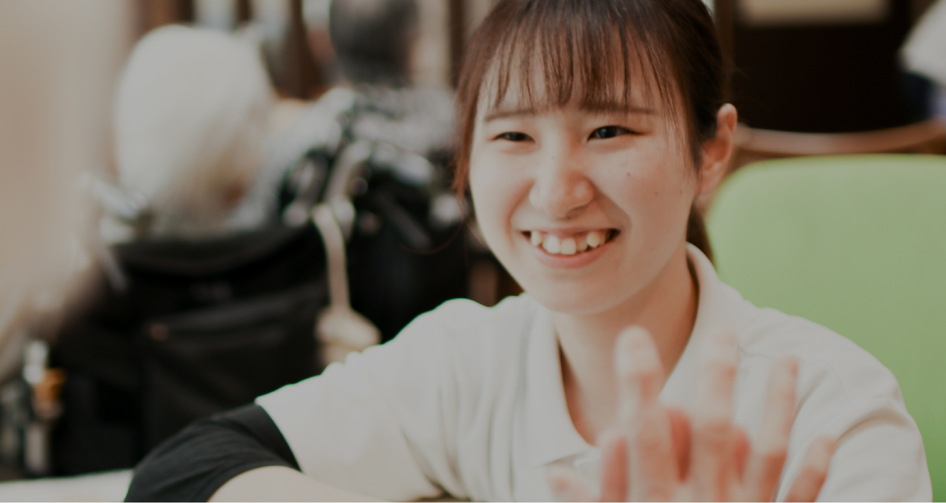 介護施設のスタッフが笑顔で手を振るポートレート写真